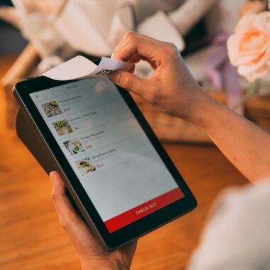 Hands using tablet for cashless payment, showcasing modern technology in retail.