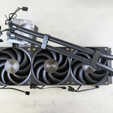 Top view of a CPU liquid cooling system with fans and cables on a light surface.